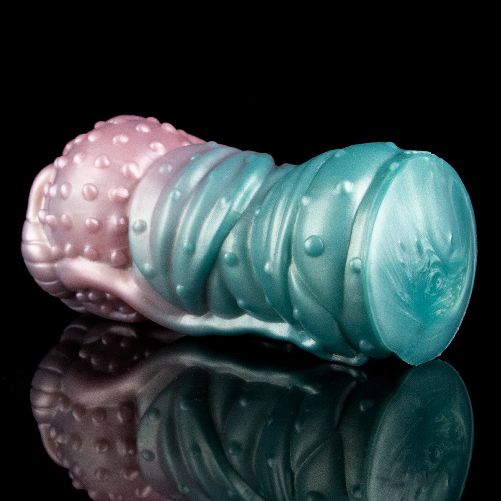 Teal end of the alien Fleshlight with glossy ridges and small raised bumps for grip.