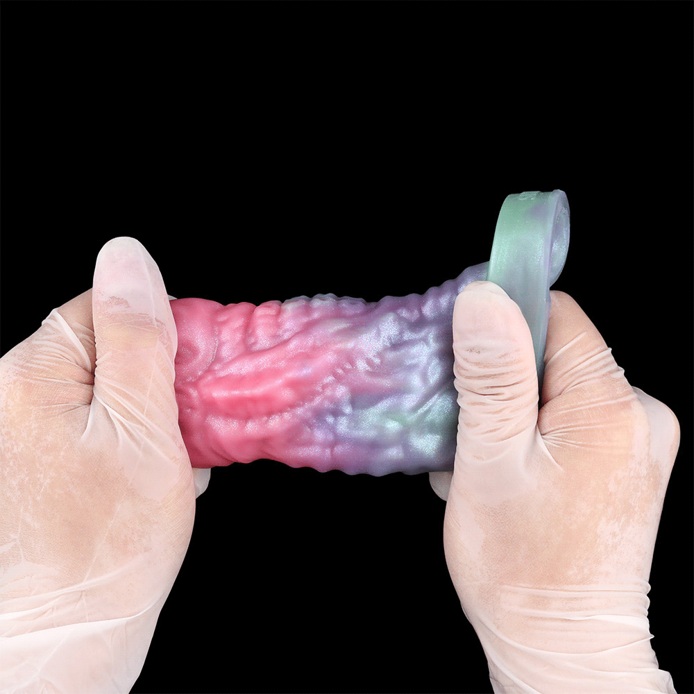 Dragon Cock Sleeve Extender zwischen Handschuhen gehalten, mehrfarbige Drachenform