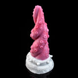 Pink octopus tentacle vibrator standing upright, textured surface and white base