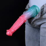 Horse-cock dildo with pink head and blue shaft, held against denim pants