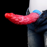Roter Drachen-Dildo am Schlauch, blauer Sockel, an Jeans getragen