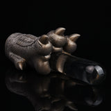 Bronze textured monster paw cover holding a black rod with silver tip