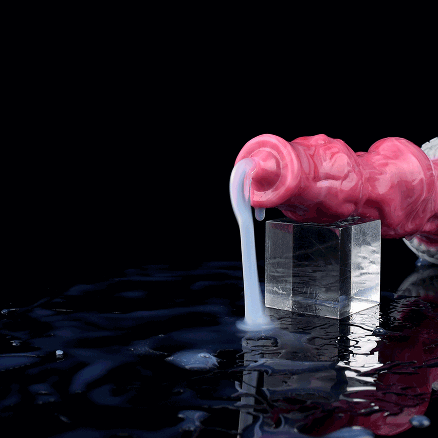 Pink translucent knot dildo with suction base sitting in reflective water