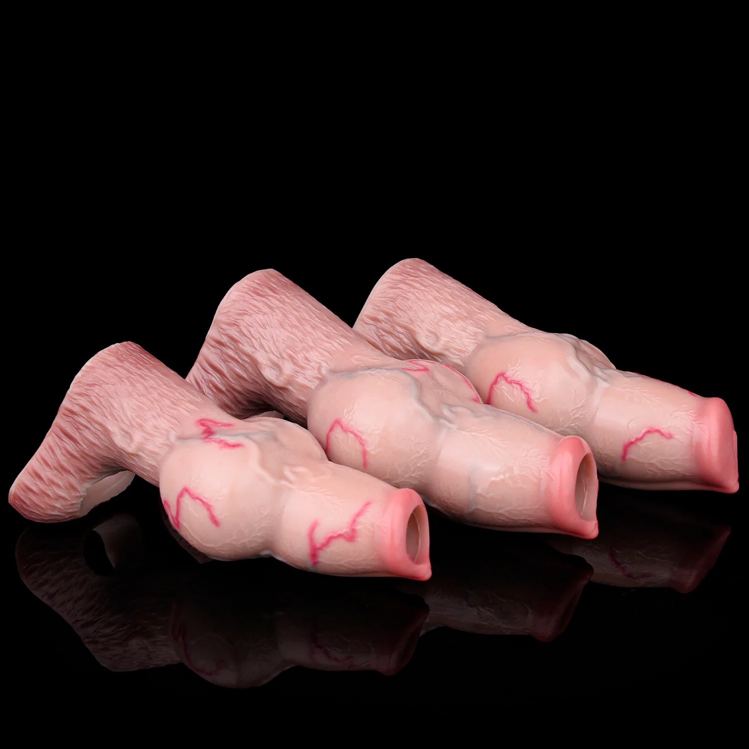 Three pink knotted dog cock sleeves laid side by side, open sheath tips visible.
