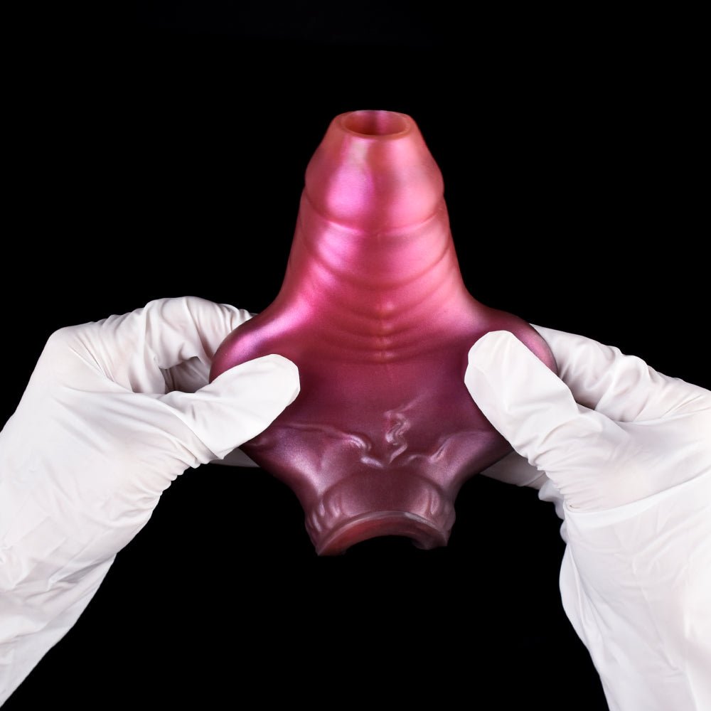 Metallic pink ribbed dragon-knot penis extender sleeve, held open by white gloves