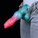 Blue and pink alien dildo tucked by denim jeans, ridged shaft and knotted base.