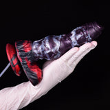 Gloved hand holding purple alien-themed squirting dildo with cum tube