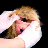 Gloved hands holding the furry hood open on a dual-hole stroker