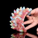 Octopus vibrating grinder close-up held by hand, multicolor spiky surface