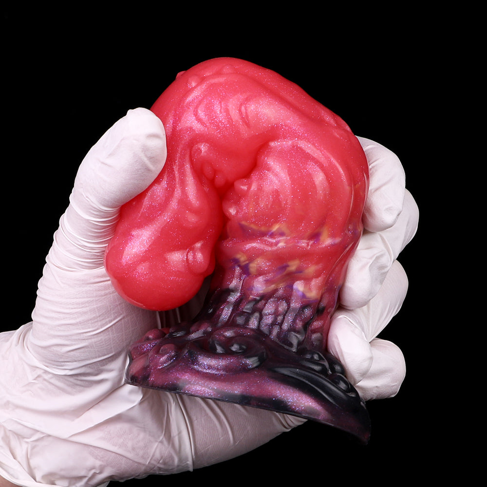 Alien butt plug underside view; glossy red ribbed body and dark purple flared base.