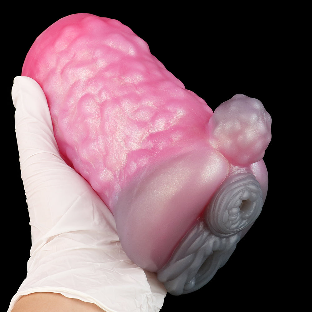 Pink animal-themed sex toy held in white glove, textured body and gray detail piece