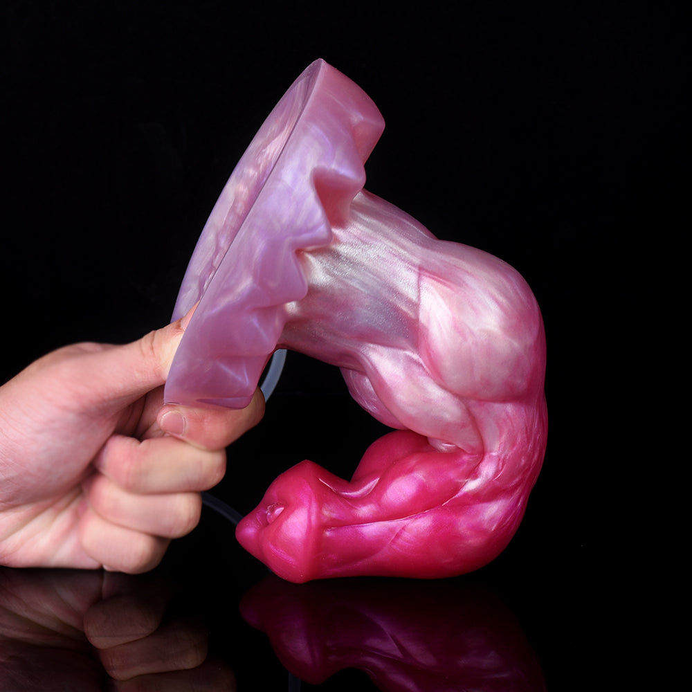 Minotaur squirting dildo side view held by hand, pink-purple with clear tube