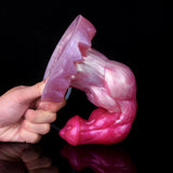 Minotaur squirting dildo side view held by hand, pink-purple with clear tube