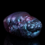 Blue-purple metallic alien head-shaped masturbator with small circular opening on side.