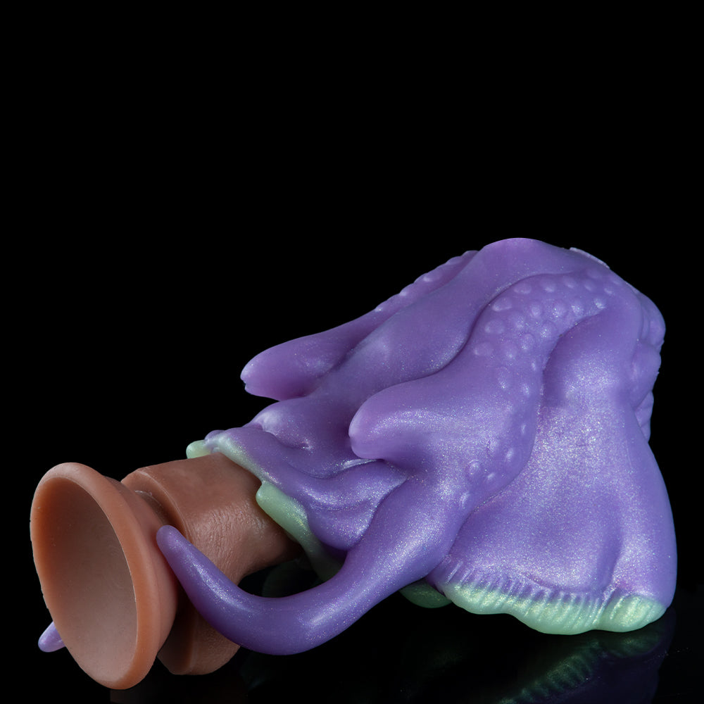 Purple alien figurine lying sideways with curled tail and round brown opening