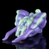 Purple and green alien figurine angled view with horned head and webbed legs