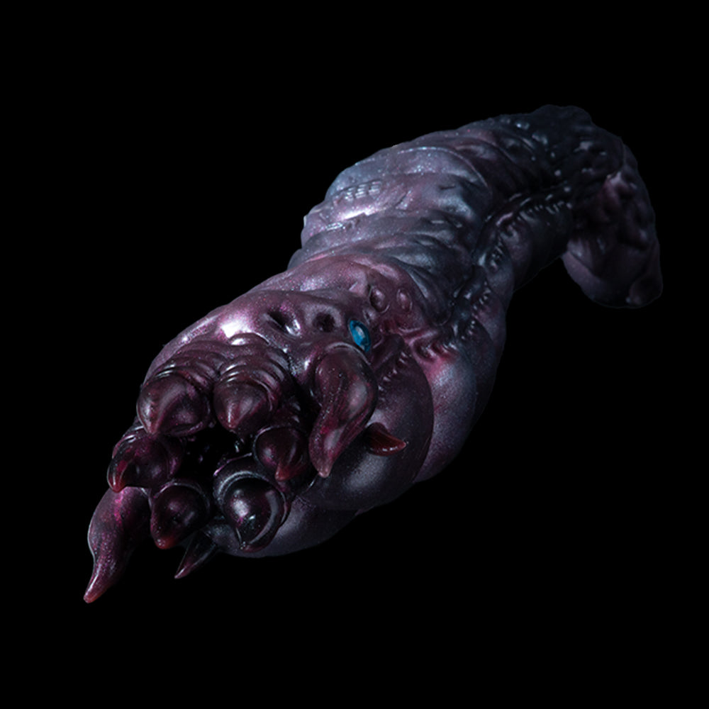 Metallic purple creature hand with clawed fingers and small blue eye detail