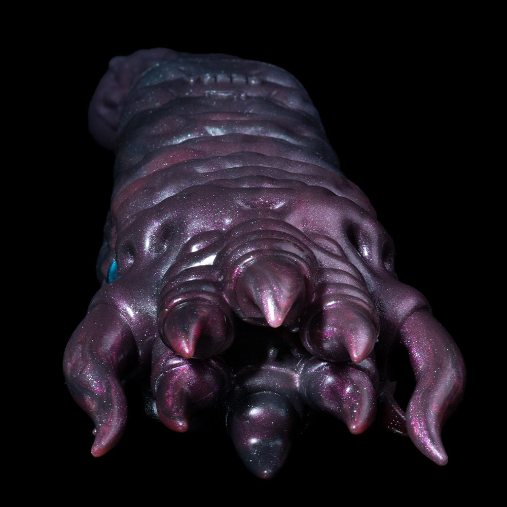 Metallic purple creature hand figure with curved claws and small blue eye detail