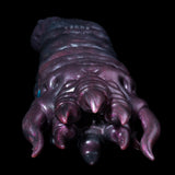 Metallic purple creature hand figure with curved claws and small blue eye detail