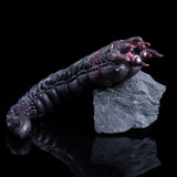 Metallic purple creature arm figure posed with clawed fingertips and blue eye