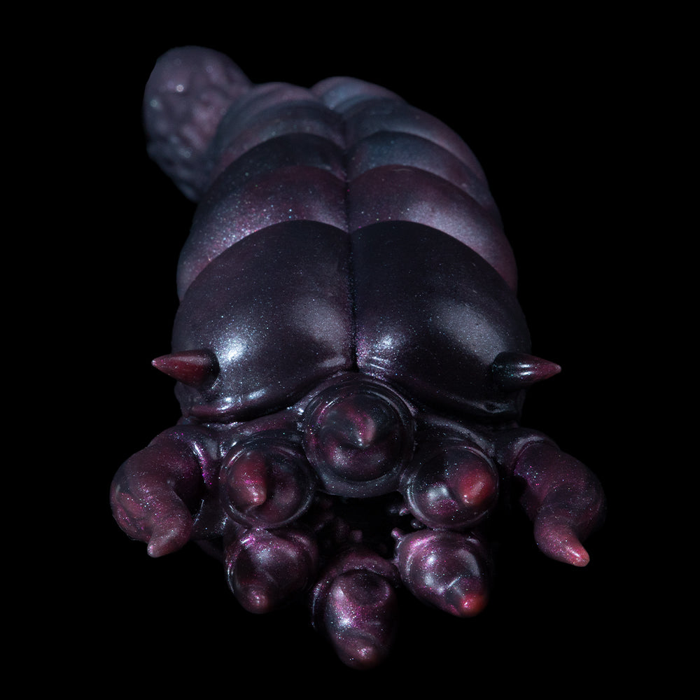 Metallic purple creature lower face with closed eyes and clawed fingers below