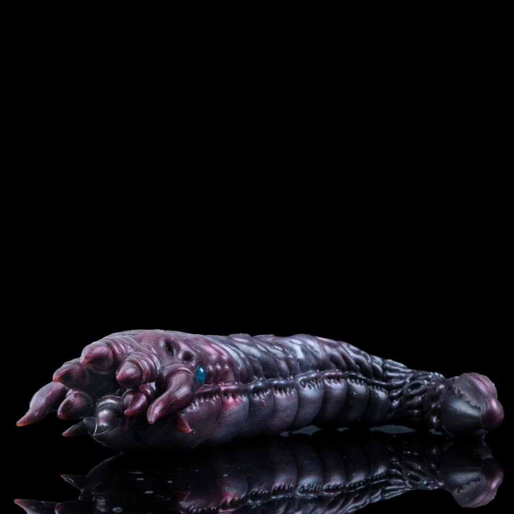 Metallic purple creature hand with curled wrist, clawed fingertips, and blue eye detail