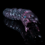 Purple and black alien creature toy with long tentacle-like arm and textured body