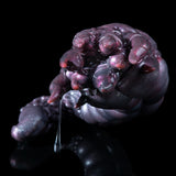 Purple alien creature toy with raised head and small claws, glossy textured skin