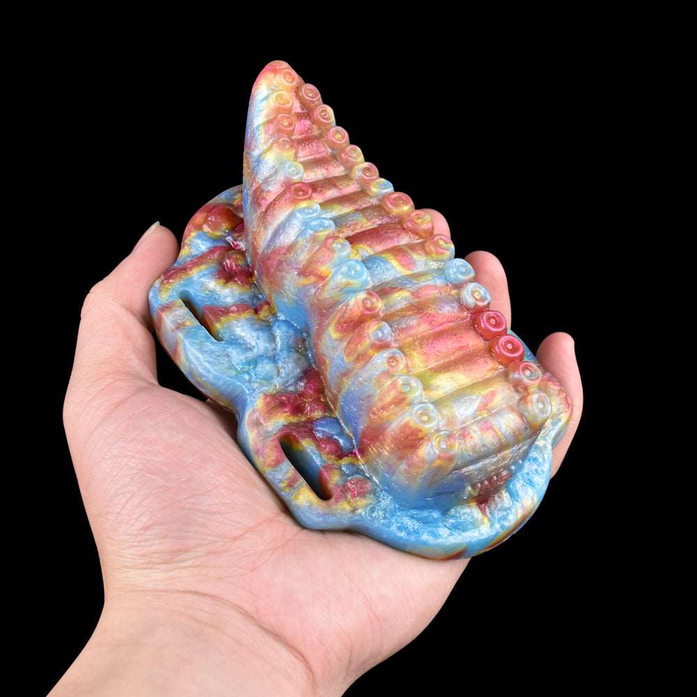 Tentacle toy in hand with rainbow ridged body and pink strap loops