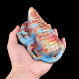 Tentacle toy in hand with rainbow ridged body and pink strap loops