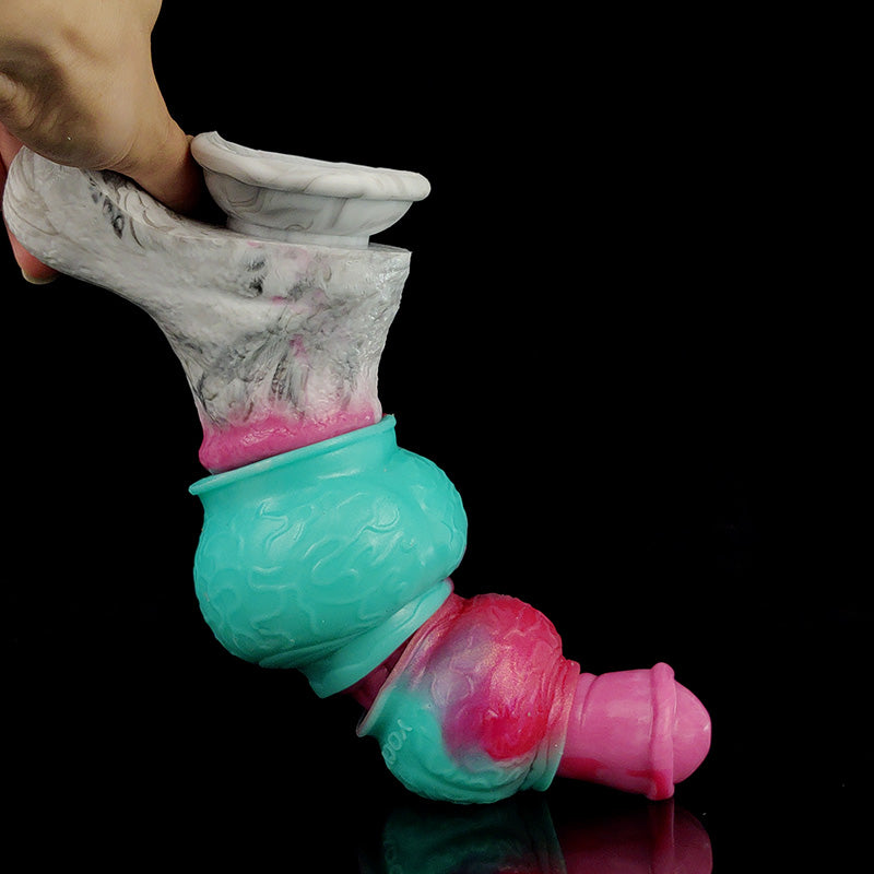 Dog knot cock ring held in hand, pink-and-teal textured swirl