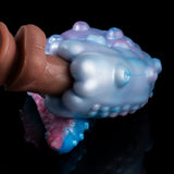 Curved blue-and-pink pleasure device close-up held in a hand, textured bumpy surface