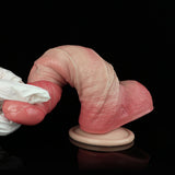 Realistic pink dildo with curved tip and suction cup base, close-up.