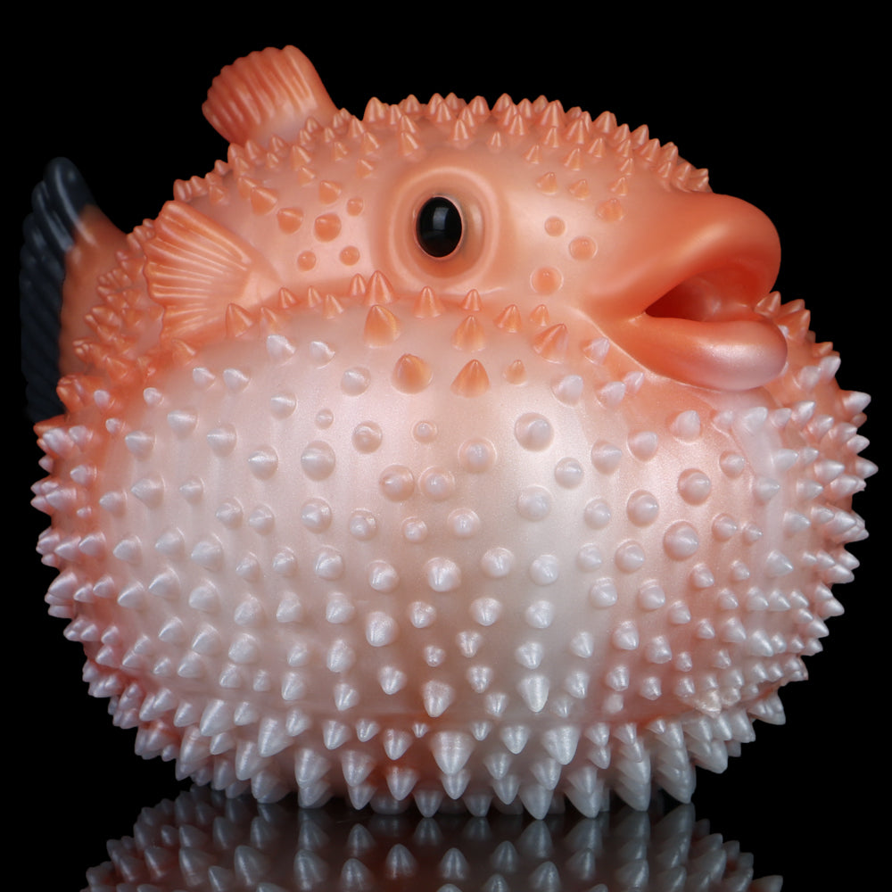 Orange and white pufferfish-shaped sex toy with black nose eye and spike texture