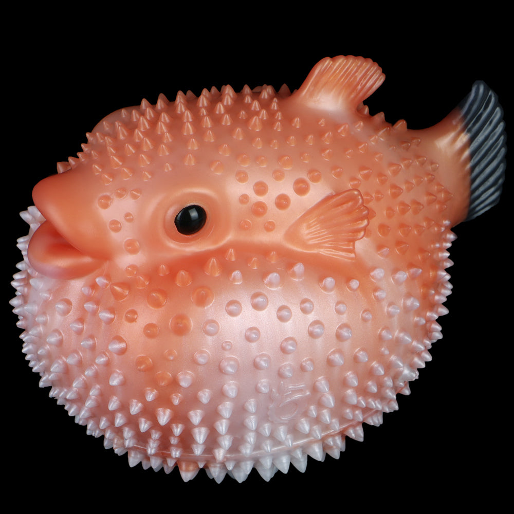 Pink pufferfish sex toy with spiky bumps, black eye, and side fin detail