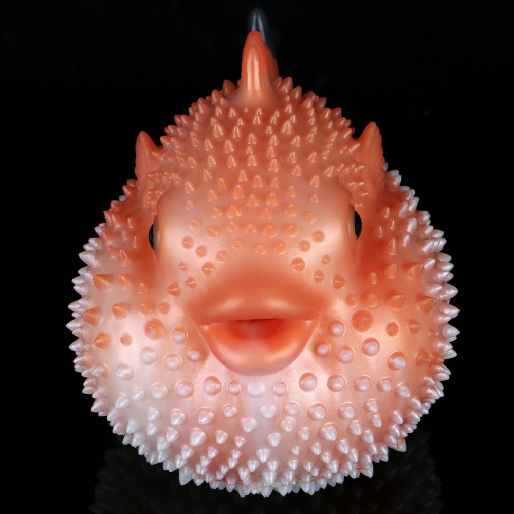 Pink pufferfish sex toy with spiked texture, open mouth, and black eye