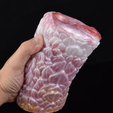Canine fleshlight stroker angled view showing pale pink ridged surface.