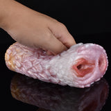 Hand holding pink canine fleshlight stroker; end opening with sculpted inner ridges.