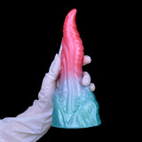 Pink dragon-style tip with light-blue textured base, viewed from back with glove.