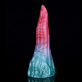 Upright view of pink tip and light-blue dragon-scale textured base on dildo.