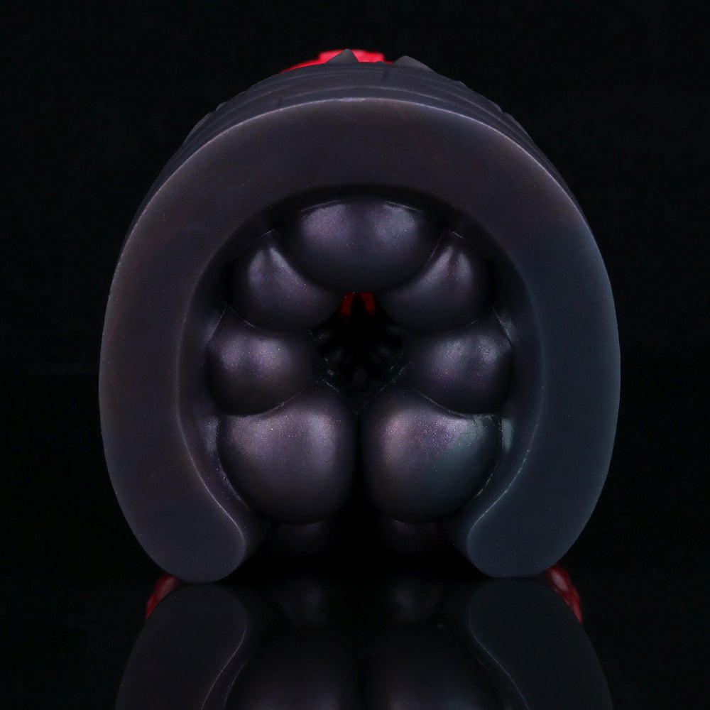 Close-up of black rounded tip with bulbous bumps on a pleasure toy.