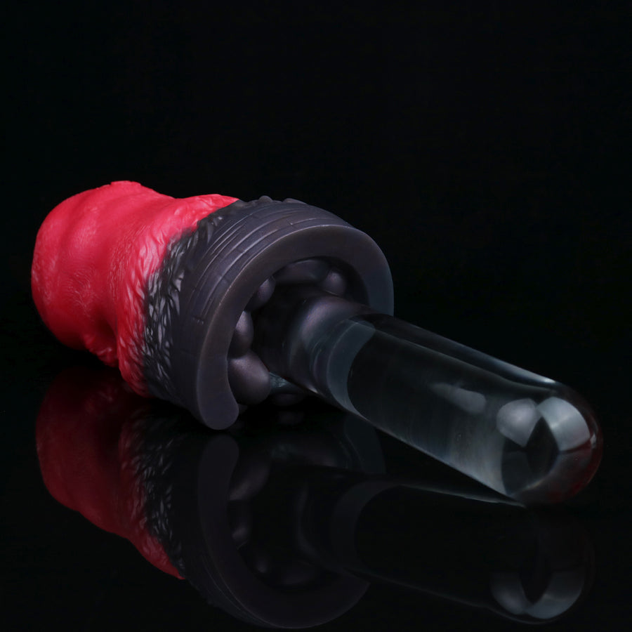 Red and black pleasure toy with clear insert tip and rounded, ribbed base.