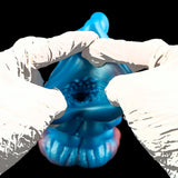 Blue alien tongue masturbator between white-gloved hands, close-up