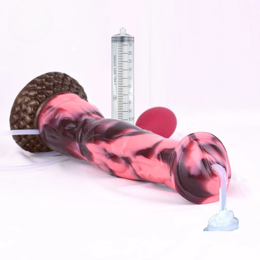Marbled horse dildo with textured base and pink-red bulb beside a measuring cylinder