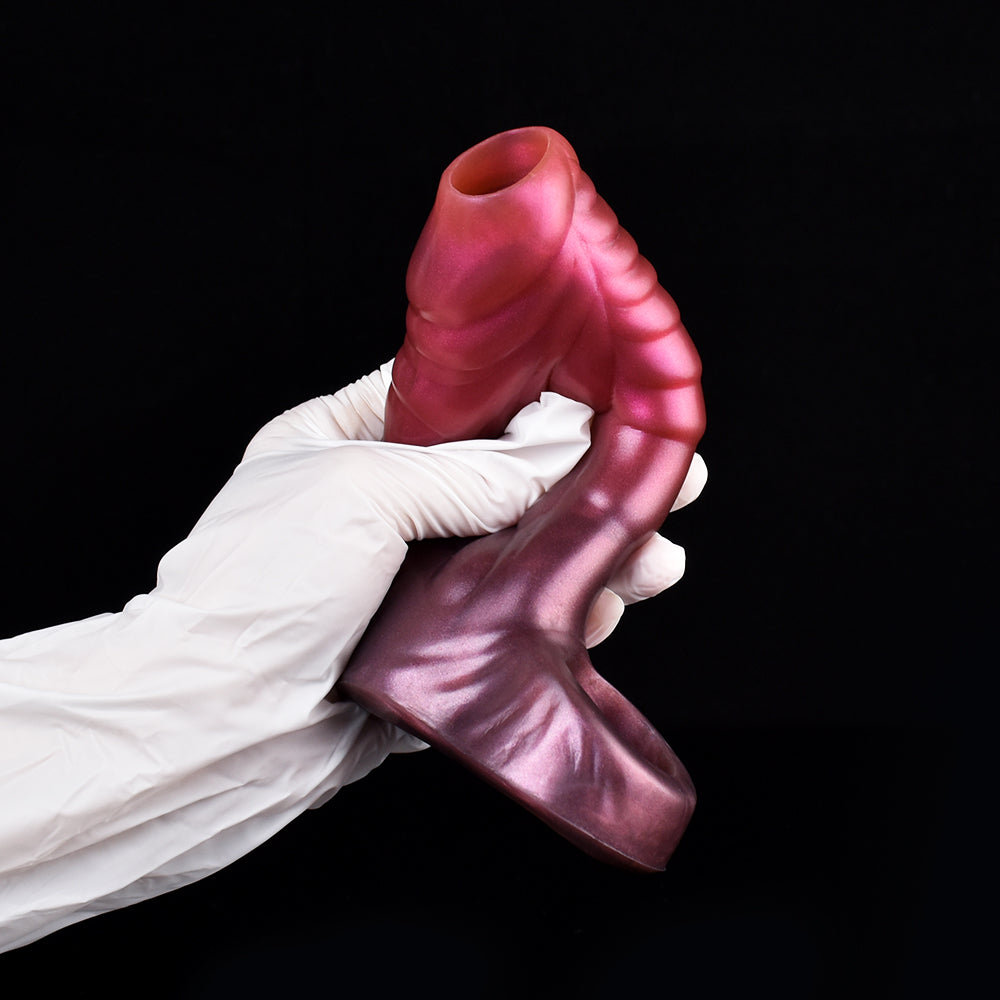 Curved dragon penis sleeve in metallic pink, gloved hands holding curved body