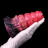 Close-up side view: glossy pink alien anal dildo with purple ribbed midsection