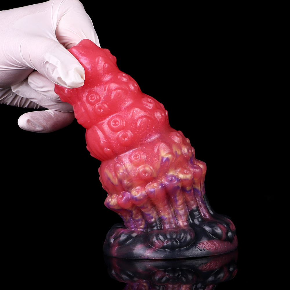 Top view: glossy pink alien anal plug with purple/black ribbed base and bumps