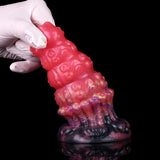 Top view: glossy pink alien anal plug with purple/black ribbed base and bumps