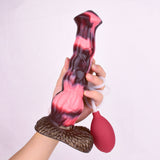 Pferde-Dildo in Hand, rot-schwarzer Körper, Schlauch-Ansatz und rote Pumpe