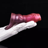 Metallic pink dog penis sleeve on gloved arm, textured surface and knot base